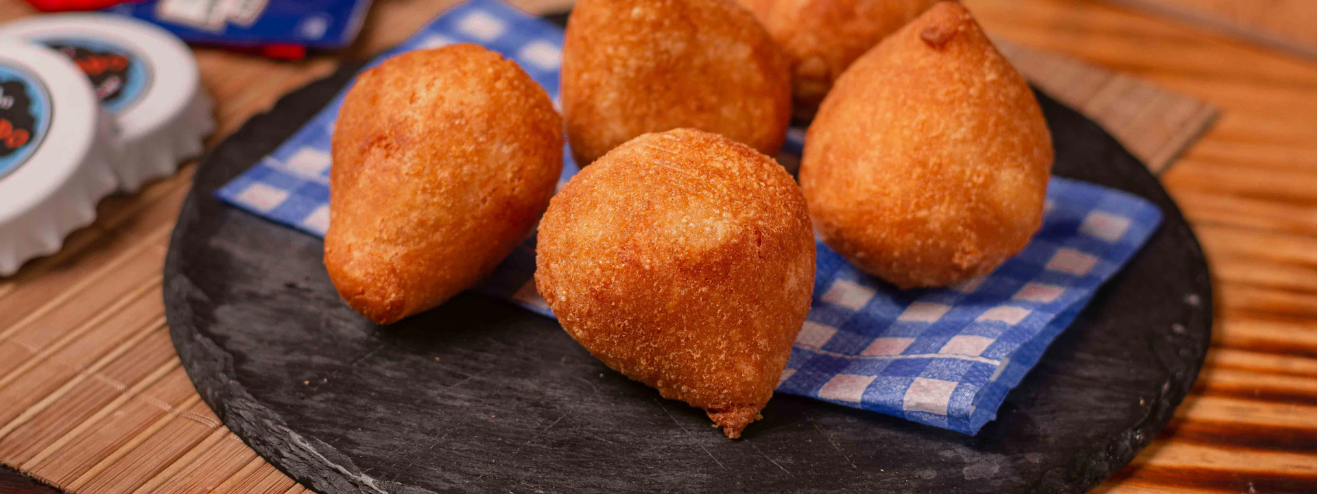 Coxinhas douradas servidas sobre uma tábua